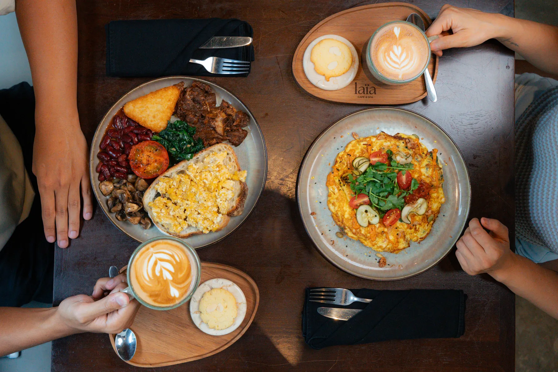 Breakfast for two with lattes served on la&iuml;a boards