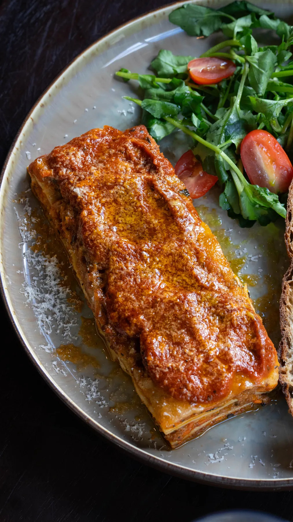 Lasagna served with a rocket and tomato salad