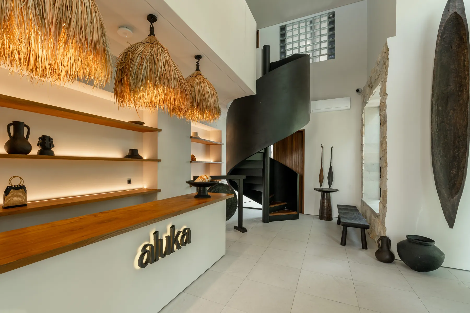 Aluka reception desk with spiral staircase and woven pendants