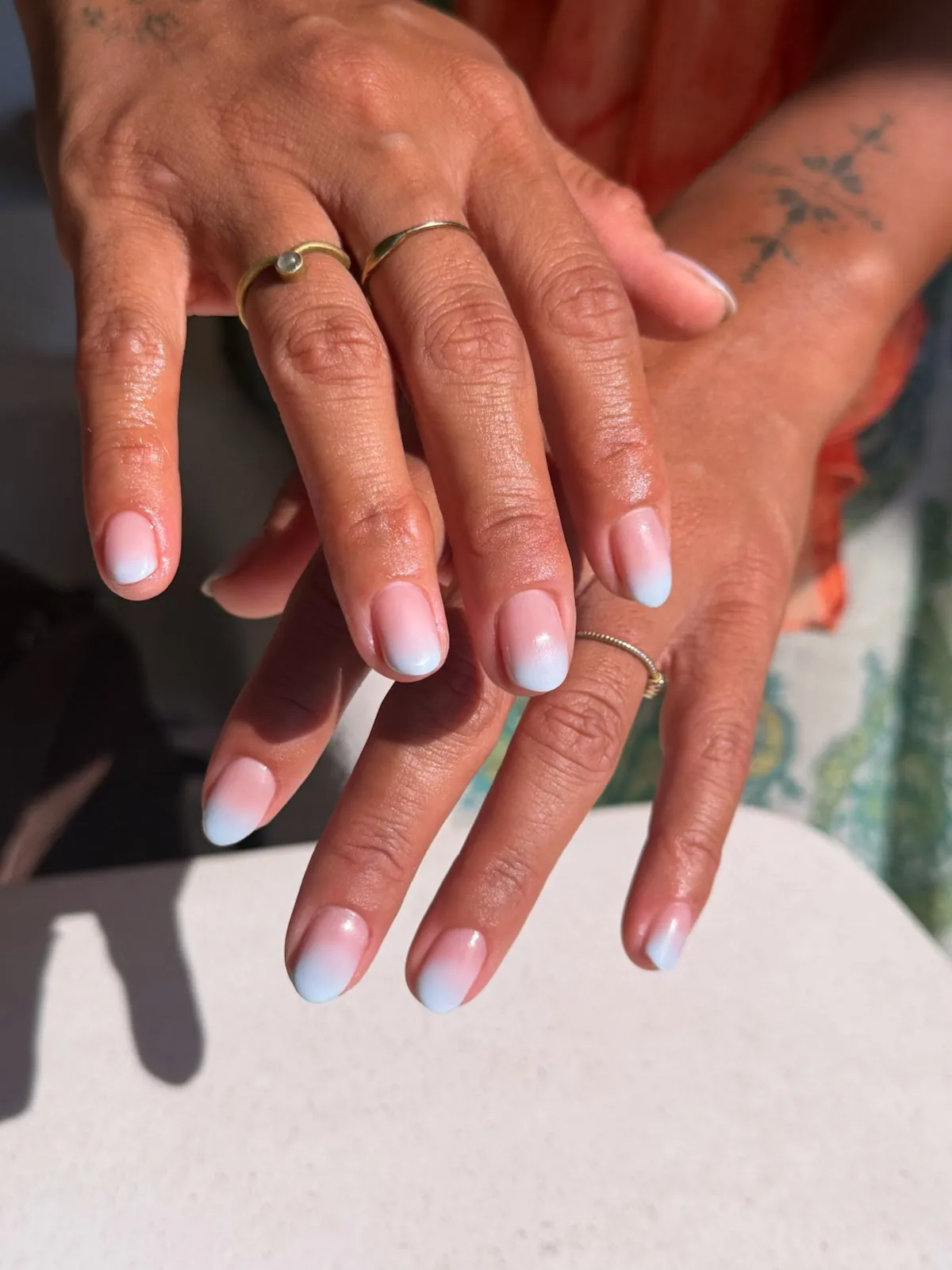 Short nails in a pink to baby blue ombre at Nāilu