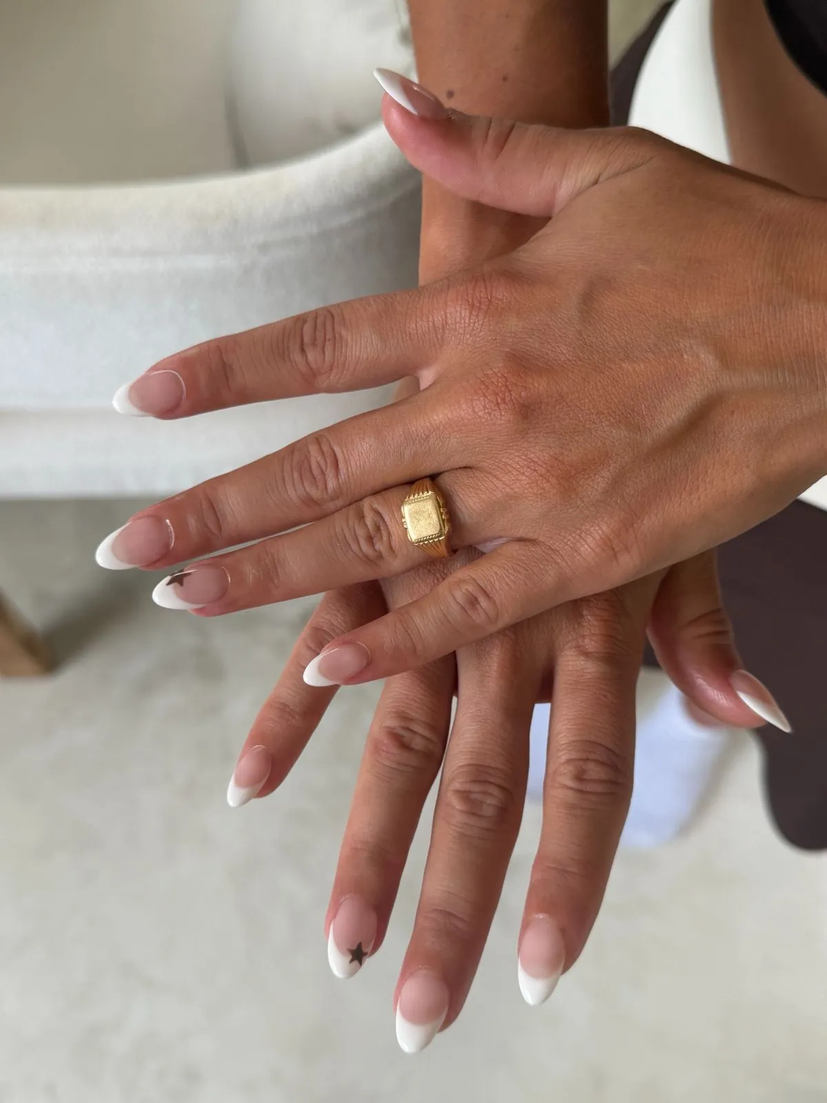 Almond French tip nails with a black star accent at Nāilu