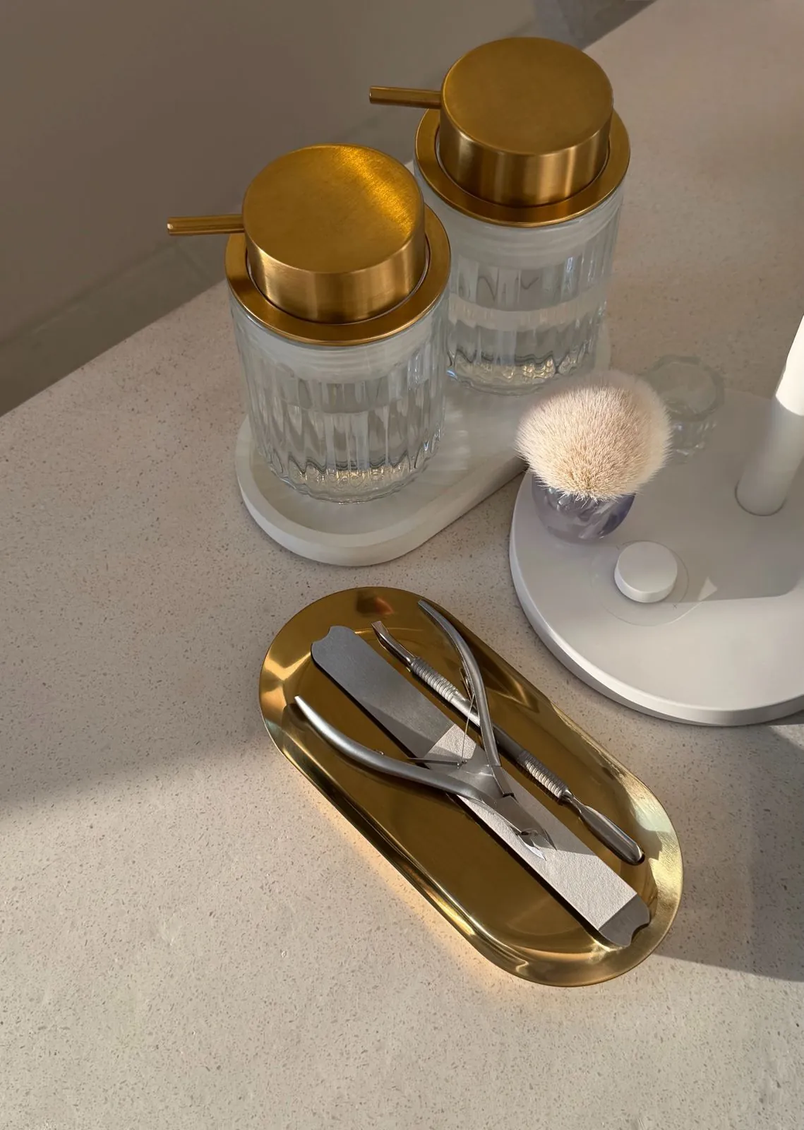 Manicure tools on a brass tray beside glass jars at Nāilu