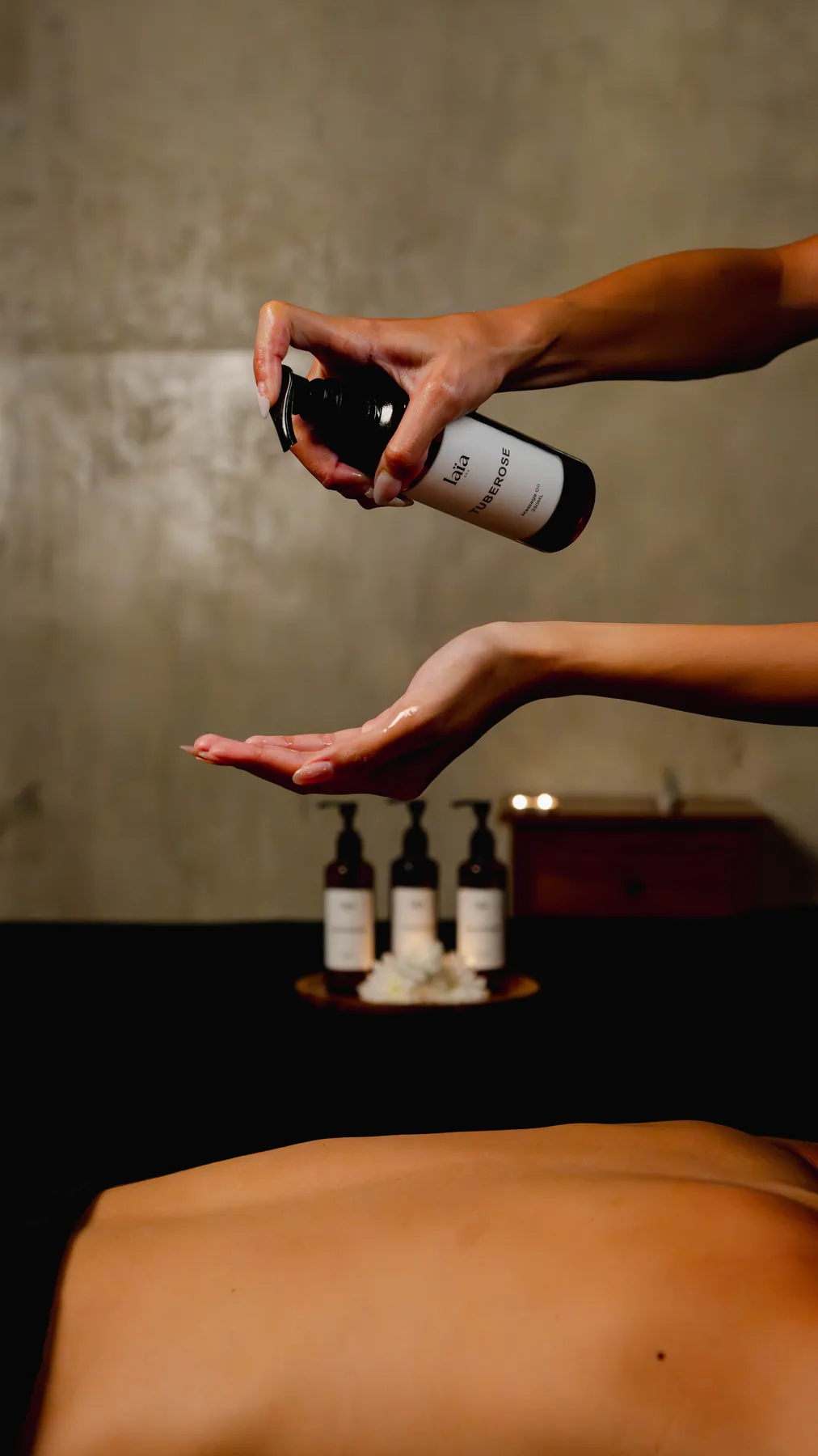Therapist pouring tuberose oil before a treatment